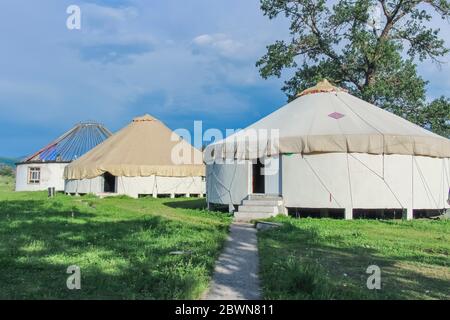 Une rangée de yourtes de construction traditionnelle dans le Kalajun Grassland, Xinjiang, Chine. Toit non terminé dans la dernière yourte Banque D'Images