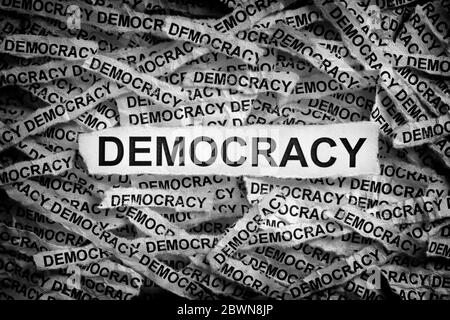 Démocratie. Morceaux de papier déchirés avec le mot démocratie. Image de concept. Noir et blanc. Gros plan. Banque D'Images