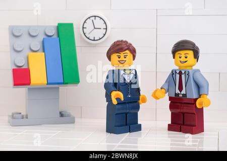 Tambov, Fédération de Russie - 29 mai 2020 deux hommes d'affaires de Lego minifigure ayant une réunion et discutant des graphiques montrant les résultats de leur succès Banque D'Images