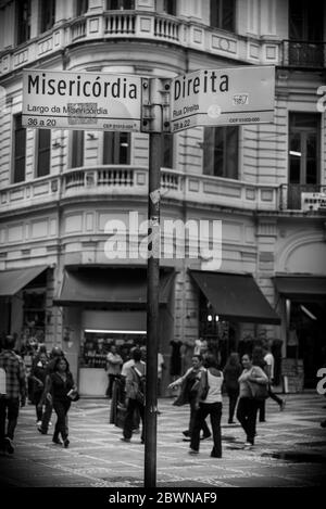 Des personnes aléatoires marchant dans les rues de Sao Paulo, avec des panneaux de rue visibles au premier plan Banque D'Images