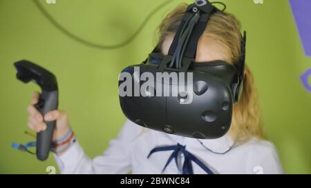 Une adolescente joue un jeu virtuel en noir de lunettes de réalité virtuelle. Banque D'Images