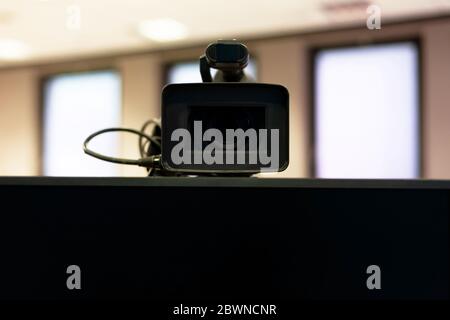 Caméra vidéo moderne professionnelle au-dessus d'un écran vierge gros plan, prise de vue frontale. Vidéo en streaming, carrière de vlogging ou résumé de téléconférence Banque D'Images