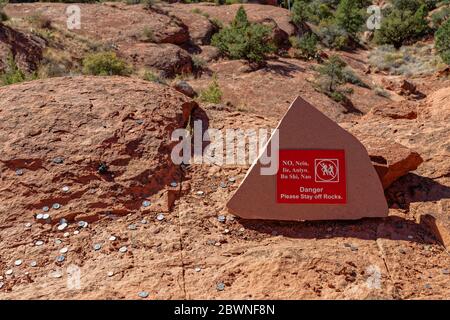 Danger signe sur les rochers dans la région de Sedona sans randonnée dans plusieurs langues, y compris le chinois, le japonais, le coréen et l'allemand ainsi que la pièce de monnaie jeté Banque D'Images