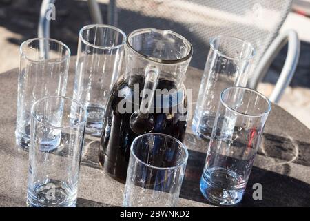 Vin croate fait maison dans une carafe de service avec 6 verres vides Banque D'Images