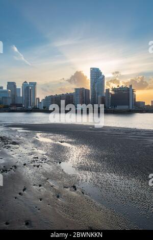 Coucher de soleil sur la Tamise avec vue sur les grands bâtiments et les méplats en terre au premier plan Banque D'Images