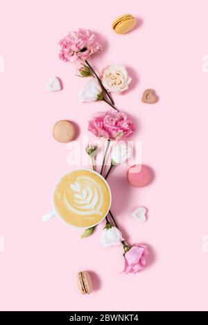 Délicieux cappuccino en fleurs et macarons sur fond rose. Émotions positives le matin. Banque D'Images