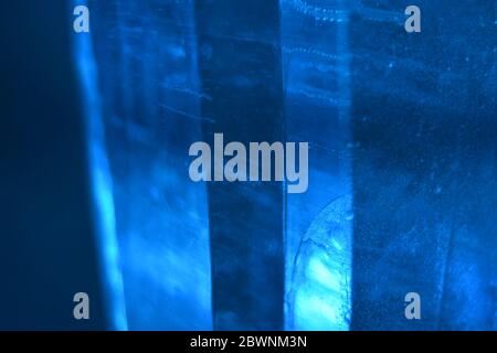 Des bulles sont piégées dans ces colonnes de glace bleue qui nagent et déforment la mise au point pour donner une photographie de texture d'arrière-plan monochromatique, le bruit réduit Banque D'Images