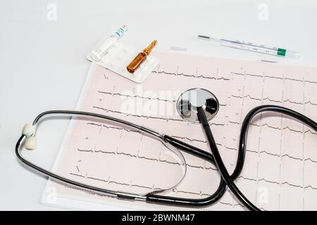 Cardiogramme avec stéthoscope, thermomètre et médicament sur table blanche. Concept de santé. Photo de haute qualité Banque D'Images