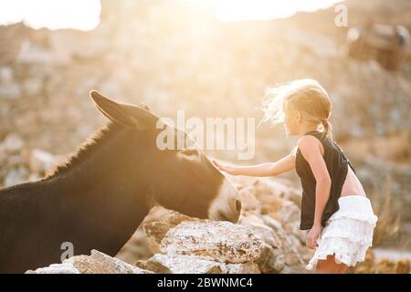 Petite fille avec un âne sur l'île de Mykonos Banque D'Images