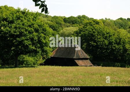 Une grange se niche dans le paysage boisé près du village de Mayfield, dans le Haut Weald de East Sussex. Banque D'Images