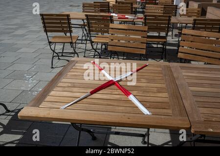 Table verrouillée avec bande rouge et blanche dans un café de rue pendant la crise du coronavirus, en gardant la distance sociale prescrite pour réduire le risque Banque D'Images