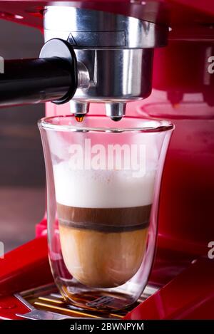 Machine à café préparant du cappuccino en verre double, gros plan Banque D'Images