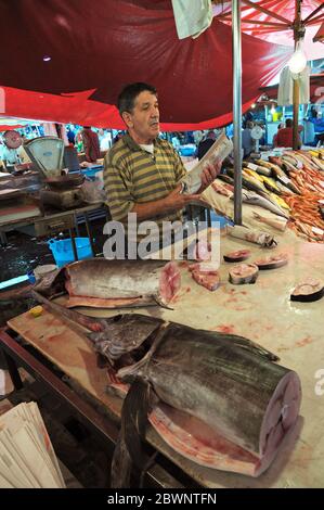 Fishmonger et son espadon à la Pescheria (marché du poisson) à Catane, Sicile, Italie Banque D'Images