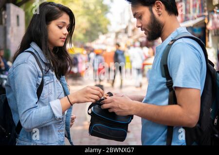 Frère aîné donnant de l'argent à sa sœur plus jeune pour faire du shopping dans le marché extérieur de rue en Inde. Banque D'Images