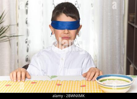 Geste de dégoût sur le visage d'un garçon de 8 ans après avoir fait un test de goût de nourriture. Banque D'Images