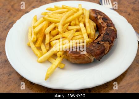 Saucisses grillées, Bratwurst allemand et frites sur une assiette dans un restaurant de restauration rapide, savoureux mais malsain manger avec des graisses trans et des fatt saturés Banque D'Images