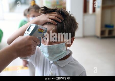 Ankara, Turquie. 2 juin 2020. La température corporelle d'un garçon est vérifiée à une école maternelle réouverte à Ankara, en Turquie, le 2 juin 2020. La pandémie de COVID-19 en Turquie a continué de ralentir mardi, avec 786 nouveaux cas d'infection enregistrés, portant le nombre total de cas confirmés à 165,555. Crédit: Mustafa Kaya/Xinhua/Alamy Live News Banque D'Images