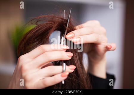 Femme a coupé les extrémités de ses cheveux dans un studio de beauté Banque D'Images