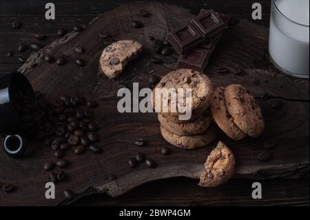 Biscuits, morceaux de chocolat et grains de café sur une planche de bois Banque D'Images