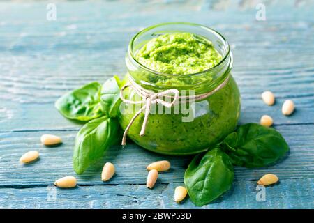 Pesto au basilic maison sur fond de bois bleu Banque D'Images