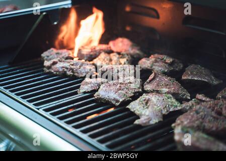 Plusieurs steaks sur le gril. Morceaux de viande, préparation de repas. Mise au point sélective. Célébration, barbecue, concept de fête Banque D'Images