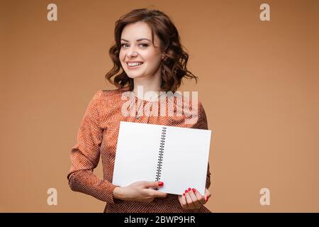 Femme souriante avec livre ouvert. Elle sourit à la caméra. Banque D'Images