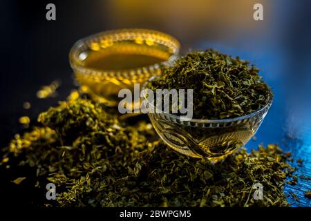 Prise de Kasuri methi cru et de sa pâte fraîchement préparée dans un bol en verre sur une surface noire brillante. Banque D'Images