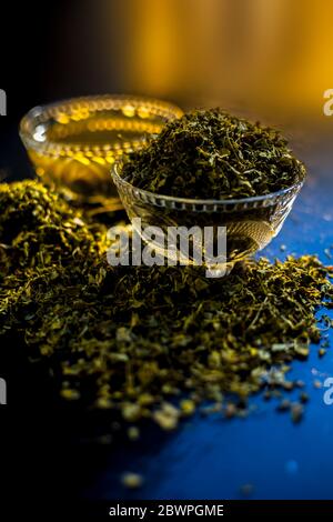 Prise de Kasuri methi cru et de sa pâte fraîchement préparée dans un bol en verre sur une surface noire brillante. Banque D'Images
