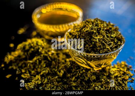 Prise de Kasuri methi cru et de sa pâte fraîchement préparée dans un bol en verre sur une surface noire brillante. Banque D'Images