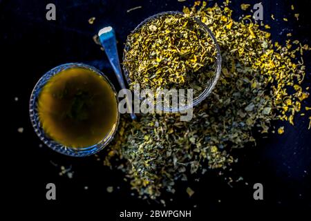 Prise de Kasuri methi cru et de sa pâte fraîchement préparée dans un bol en verre sur une surface noire brillante. Banque D'Images