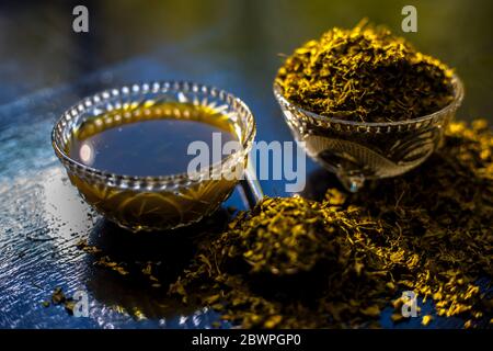 Prise de Kasuri methi cru et de sa pâte fraîchement préparée dans un bol en verre sur une surface noire brillante. Banque D'Images