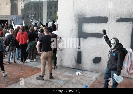 Un manifestant se tient devant un mur récemment graffiti devant le Justice Center, qui abrite la police de Cleveland, lors des manifestations à Cleveland, Ohio, États-Unis. Banque D'Images