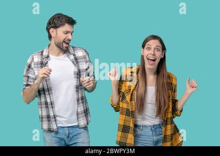 Jeune homme et fille qui danse avec des bouches ouvertes. Banque D'Images