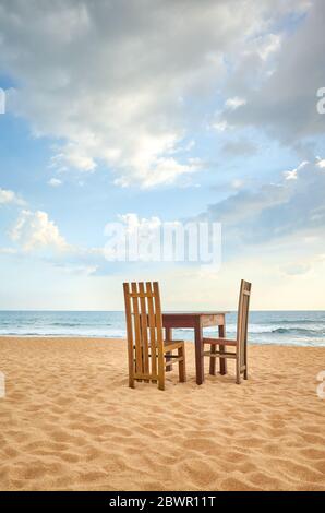 Table en bois et deux chaises sur une plage. Banque D'Images