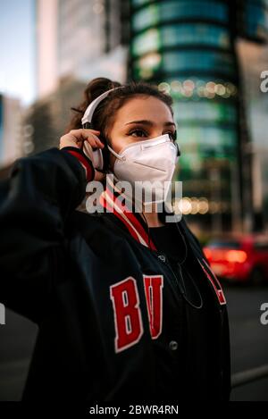 une jeune fille vêtue de sport porte un masque médical dans la rue de la ville en espagne. Pandémie de coronavirus Covid-19 Banque D'Images