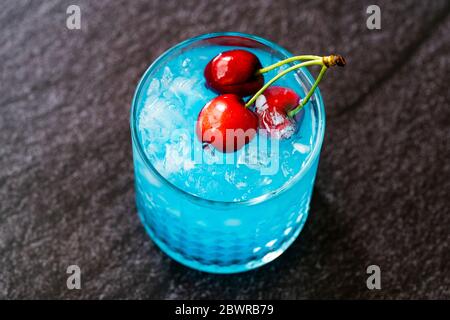 Cocktail Blue Lagoon avec cerises et glace pilée. Prêt à boire. Banque D'Images