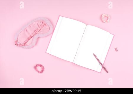 Journal avec un joli masque de sommeil moelleux et des accessoires roses. Gestion et optimisation du sommeil, concept de sommeil et de journal de sommeil de beauté. Placer pour le texte Banque D'Images