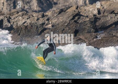 Une femelle à surfer une vague de Fistral Newquay en Cornouailles. Banque D'Images