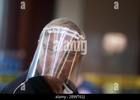 Un employé du bureau de scrutin porte un masque de protection contre la COVID-19 à l'hôtel de ville pendant le premier jour des élections de l'Indiana. Les élections primaires ont lieu à Bloomington, dans l'Indiana, après la fermeture des bureaux de vote à l'école primaire de Grandview le jour des élections primaires de l'Indiana, le 2 juin 2020. Banque D'Images