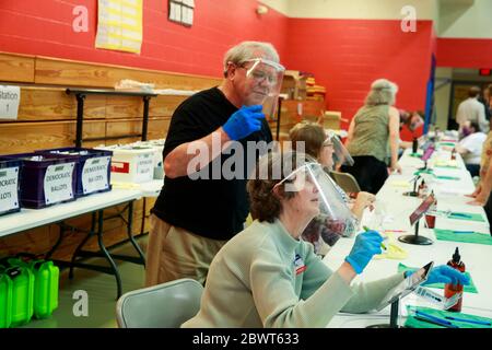 Les employés des sondages portent des écrans faciaux et des gants de protection contre Covid-19 lors du premier jour des élections dans l'Indiana.les élections primaires ont lieu à Bloomington, dans l'Indiana, après la fermeture des sondages à l'école primaire Grandview le jour des élections primaires dans l'Indiana, le 2 juin 2020. Banque D'Images