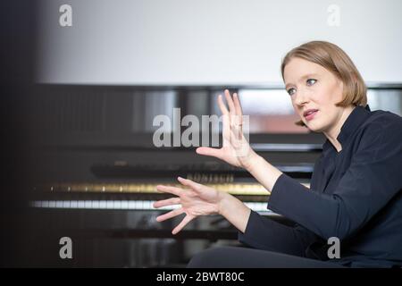 Nuremberg, Allemagne. 25 mai 2020. Joana Mallwitz, chef d'orchestre et directrice générale de la musique au Staatstheater de Nuremberg, est assise dans son bureau pendant une interview. Peu à peu, les théâtres et les salles de concert peuvent rouvrir. Mais la normalité est loin d'être en vue. Le chef d'orchestre Mallwitz tente de tirer le meilleur parti de la crise de manière artistique. Crédit : Daniel Karmann/dpa/Alay Live News Banque D'Images