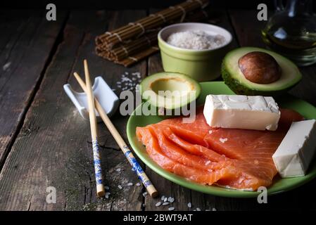 Ingrédients asiatiques traditionnels steak de saumon frais poêlé, riz non cuit, avocat, sur fond de bois vieux sheese Banque D'Images