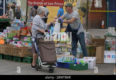 Le marché de Romford rouvre pour la première fois depuis le début de la crise de Covid-19. Historiquement, le marché de Romford, pour lequel une charte a été accordée par le roi Henry III, a commencé il y a près de 800 ans en 1247. Établi à l'origine comme un marché de moutons, il est toujours l'un des plus grands marchés de rue du Sud-est avec plus de 150 stands réguliers offrant une gamme variée de produits, y compris la viande fraîche et le poisson, Fruits et légumes avec vêtements et autres articles de mode. Le marché fonctionne trois jours par semaine le vendredi et le samedi. Les marchés ont été autorisés à rouvrir à partir du 1er juin après un certain verrouillage Banque D'Images