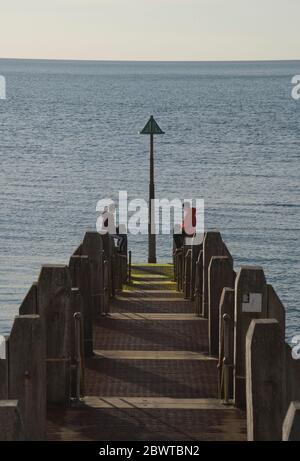 Les gens se détendent sur le front de mer après que le gouvernement gallois ait assoupli les restrictions de verrouillage en raison de la pandémie de coronavirus Covid19 pour permettre plus d'exercice et de bains de soleil sur les plages. Aberystwyth,Ceredigion,pays de Galles,Royaume-Uni Banque D'Images