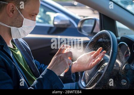 Pulvérisation de désinfectant antibactérien en aérosol à portée de main dans la voiture, concept de contrôle des infections. Banque D'Images