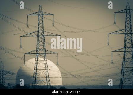 Centrale nucléaire de Sizewell B avec plusieurs pylônes d'électricité en face vu par une brume de chaleur faussant en monochrome Banque D'Images