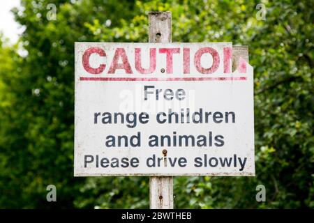 PANNEAU DE MISE EN GARDE avertissant les automobilistes d'enfants et d'animaux à portée libre, veuillez conduire lentement, campagne du Royaume-Uni. Banque D'Images