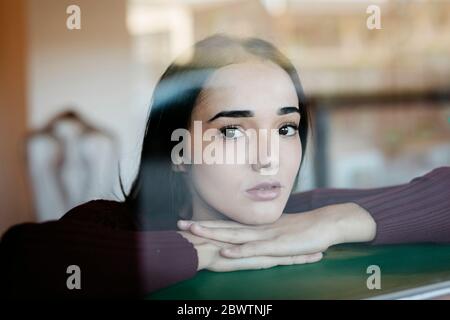 Portrait de jeune femme derrière la vitre Banque D'Images