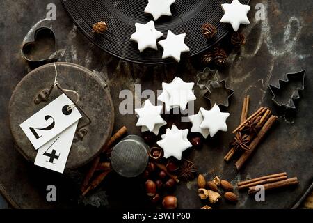 Plaque de cuisson rustique, bâtonnets de cannelle, biscuits de Noël en forme d'étoile, emporte-pièces, noix et boîte cadeau en métal Banque D'Images