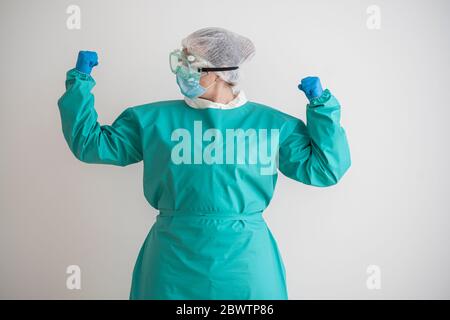 Femme portant un équipement de protection personnel qui fléchit ses muscles Banque D'Images